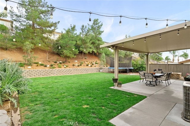 view of yard featuring a fenced backyard, a patio, and a trampoline