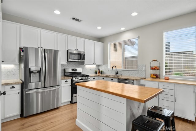 kitchen featuring visible vents, butcher block countertops, a sink, appliances with stainless steel finishes, and light wood finished floors