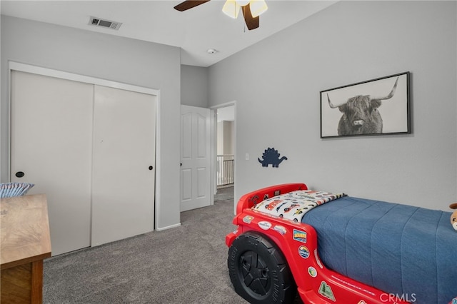 carpeted bedroom featuring visible vents, a closet, and ceiling fan