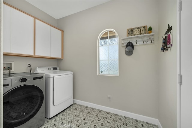 laundry room with washer and dryer, cabinet space, baseboards, and light floors