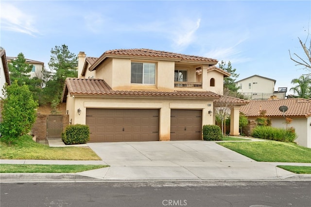 mediterranean / spanish house with a tiled roof, concrete driveway, stucco siding, a chimney, and a garage