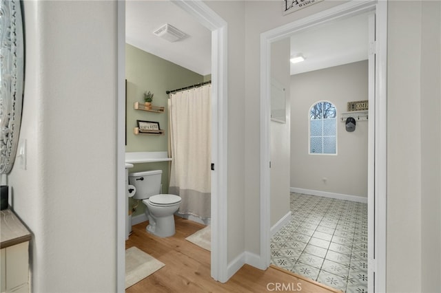 full bathroom with visible vents, toilet, baseboards, and wood finished floors