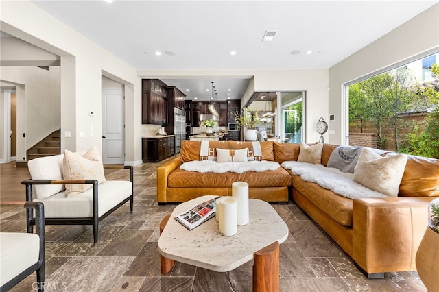 living area featuring recessed lighting, stairway, visible vents, and stone finish floor