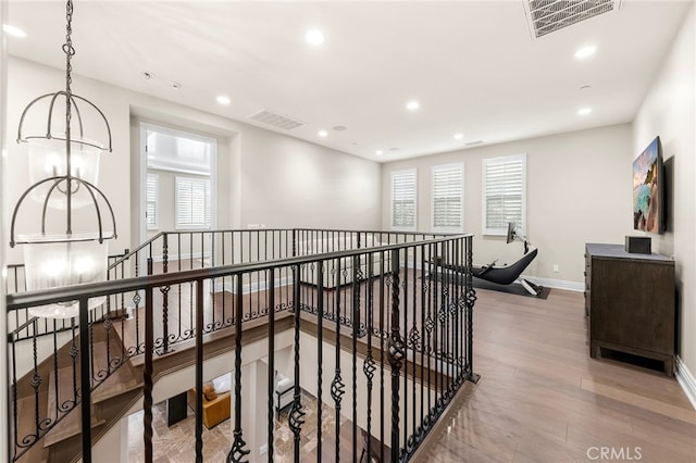 corridor featuring recessed lighting, an upstairs landing, wood finished floors, and visible vents