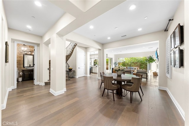 dining area featuring recessed lighting, stairway, baseboards, and wood finished floors