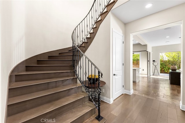 staircase with recessed lighting, baseboards, and wood finished floors