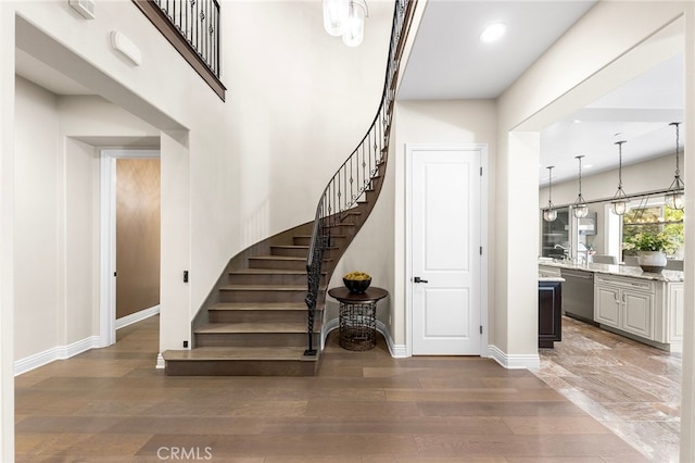 staircase with recessed lighting, wood finished floors, and baseboards