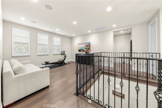 hall with visible vents, baseboards, an upstairs landing, recessed lighting, and wood finished floors