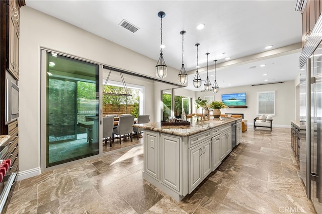 kitchen featuring visible vents, a kitchen island, recessed lighting, baseboards, and hanging light fixtures