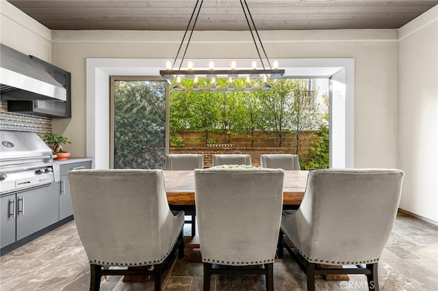 dining area featuring stone tile floors and a chandelier