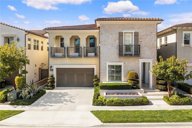 mediterranean / spanish house with a tile roof, stucco siding, a balcony, a garage, and driveway