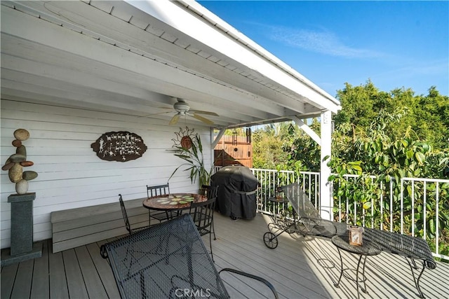 wooden deck featuring a ceiling fan and a grill