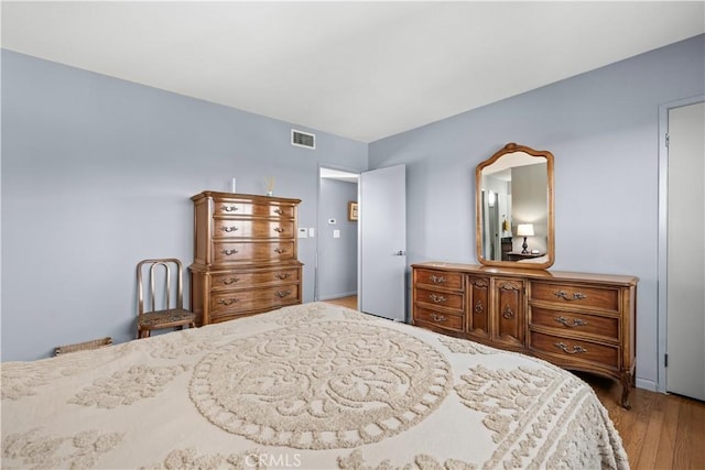 bedroom with visible vents and wood finished floors