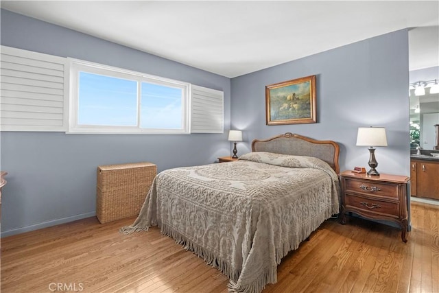 bedroom featuring baseboards and hardwood / wood-style flooring