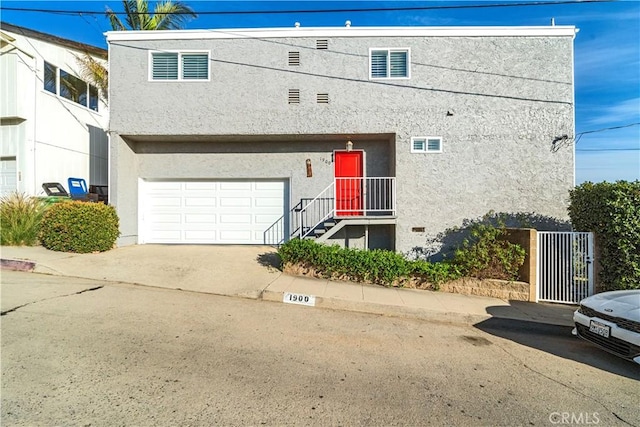 multi unit property featuring stucco siding, driveway, and a garage