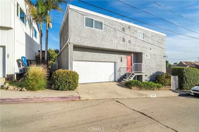 view of front of house with stucco siding, a garage, and concrete driveway