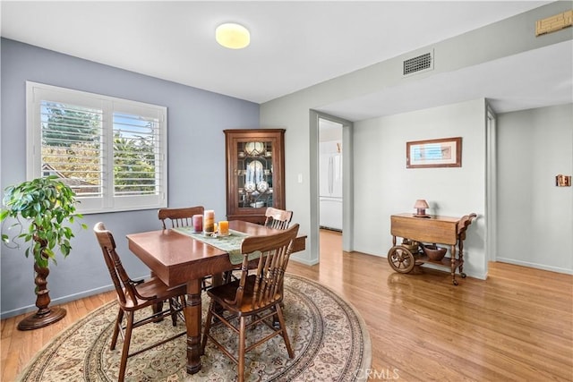 dining area with visible vents, baseboards, and light wood-style floors