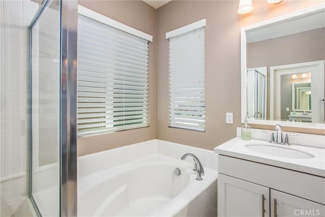 full bathroom with a bath, a shower stall, and vanity