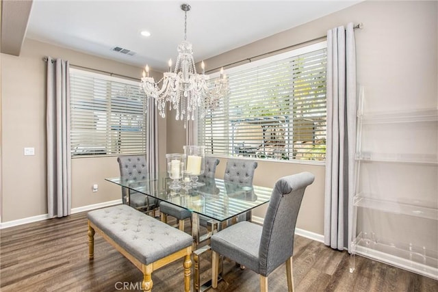 dining space with visible vents, an inviting chandelier, baseboards, and wood finished floors