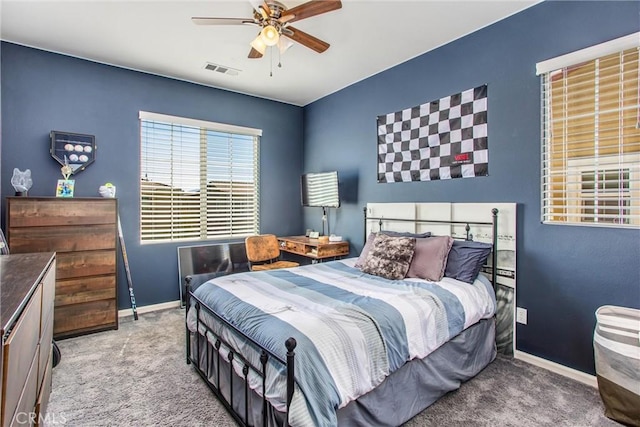 carpeted bedroom with visible vents, a ceiling fan, and baseboards