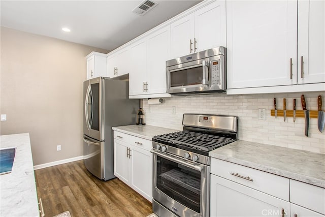 kitchen featuring tasteful backsplash, visible vents, stainless steel appliances, dark wood-style floors, and white cabinetry