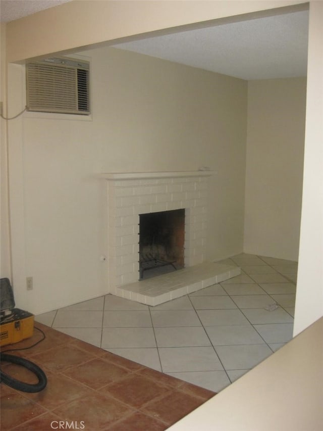 unfurnished living room featuring a brick fireplace, tile patterned flooring, and a wall mounted AC