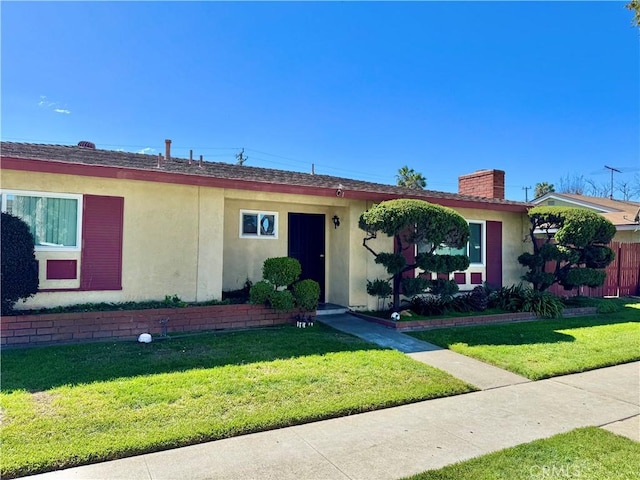 single story home featuring a front yard, a chimney, and stucco siding