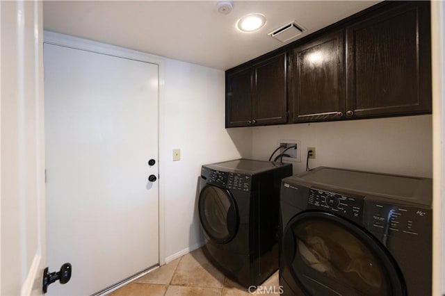 washroom with washer and clothes dryer, visible vents, cabinet space, and light tile patterned flooring