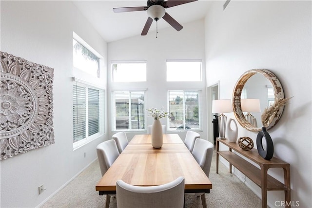 dining room featuring ceiling fan, carpet flooring, baseboards, and high vaulted ceiling