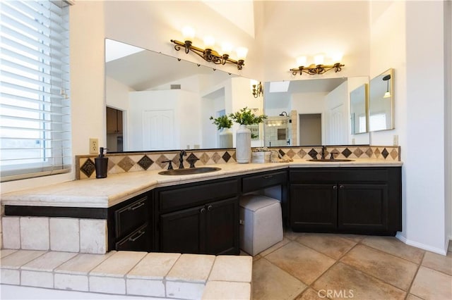 bathroom featuring a sink, tasteful backsplash, and double vanity