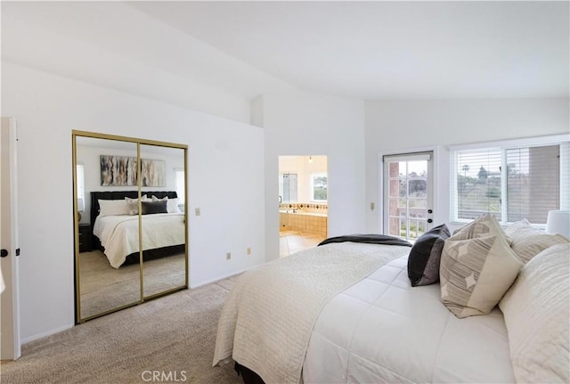 carpeted bedroom featuring vaulted ceiling, a closet, and connected bathroom