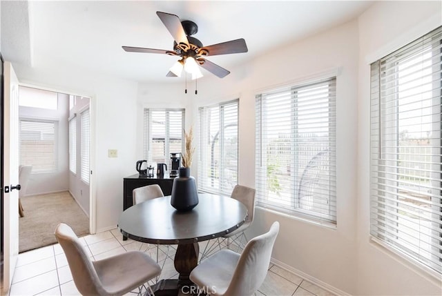 dining area featuring light tile patterned floors, baseboards, and a ceiling fan