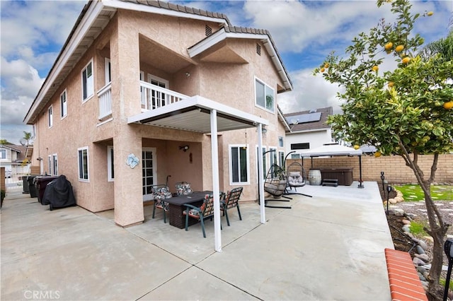 back of property featuring a patio, a balcony, a fenced backyard, and stucco siding