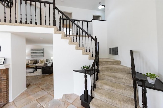 staircase featuring tile patterned floors and visible vents