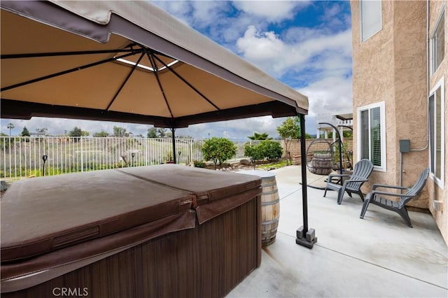 view of patio featuring a gazebo, a hot tub, and fence