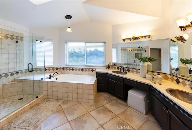 full bath with a sink, double vanity, a bath, and a shower stall