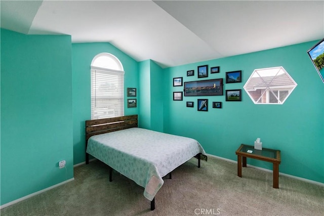 bedroom with baseboards, lofted ceiling, and carpet