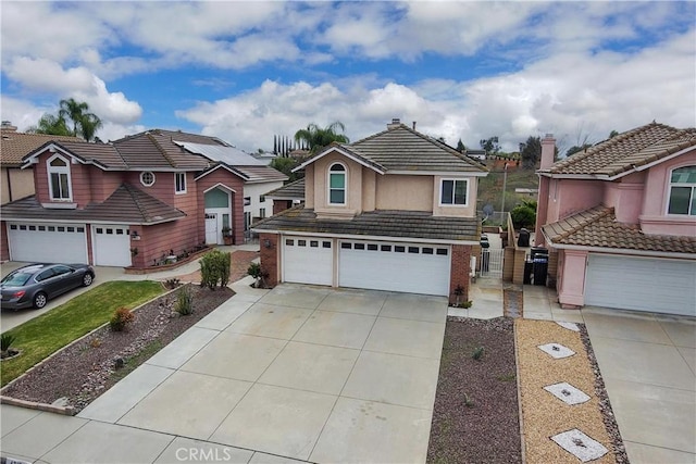 view of front of house featuring driveway, an attached garage, stucco siding, a tile roof, and brick siding