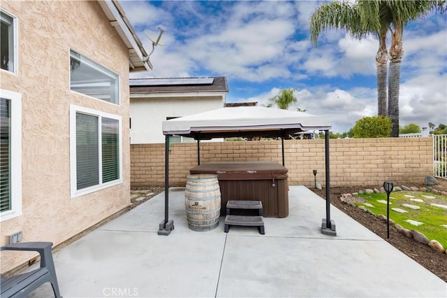 view of patio / terrace with a gazebo, fence, and a hot tub