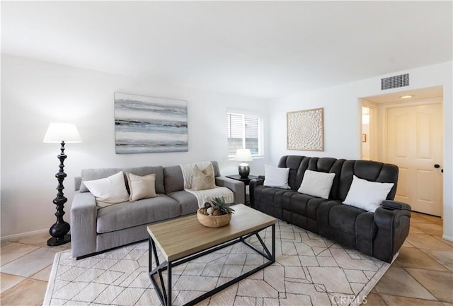 living area with light tile patterned flooring, visible vents, and baseboards