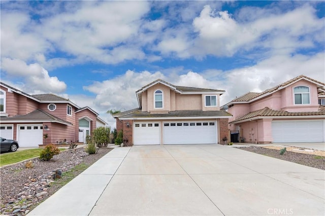 view of front of home with concrete driveway, an attached garage, brick siding, and stucco siding