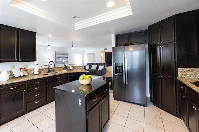 kitchen with light tile patterned floors, a tray ceiling, a sink, crown molding, and stainless steel fridge