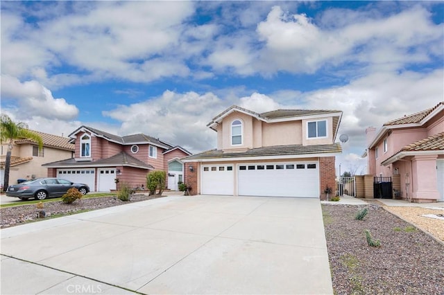 traditional home featuring a garage, brick siding, concrete driveway, and a gate