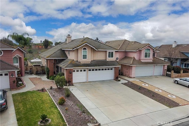 view of front of house featuring driveway, a chimney, a garage, a tiled roof, and brick siding