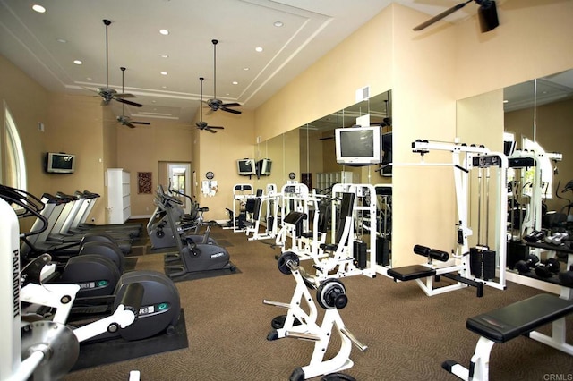 exercise room with recessed lighting, a high ceiling, and ceiling fan