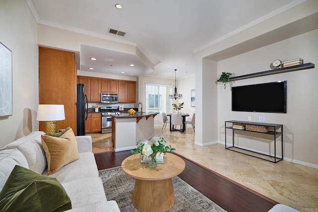 living area with light wood-style flooring, baseboards, a notable chandelier, and ornamental molding