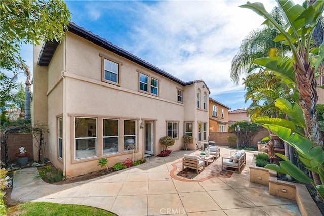 rear view of property with outdoor lounge area, a patio area, a fenced backyard, and stucco siding