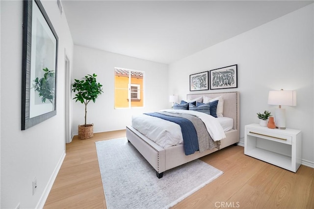 bedroom featuring baseboards and light wood-style flooring