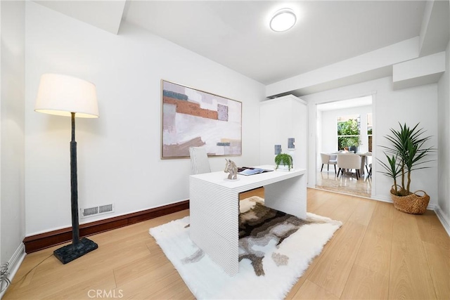 office featuring light wood-type flooring, visible vents, and baseboards