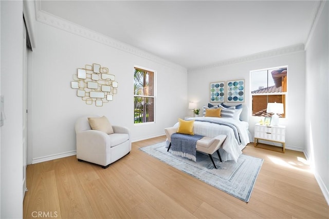 bedroom featuring crown molding, baseboards, and light wood-type flooring